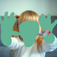 Blonde toddler with paint-covered hands smiles at the camera, holding out hands.