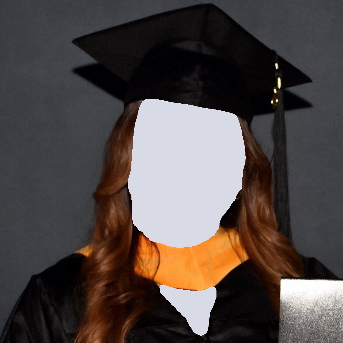 Woman in graduation cap and gown, smiling, with a gold collar, against a gray background.