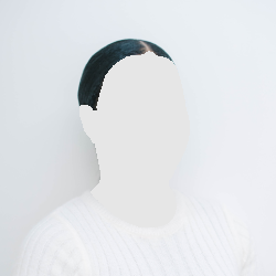 Woman in a white sweater smiling in front of a white wall.