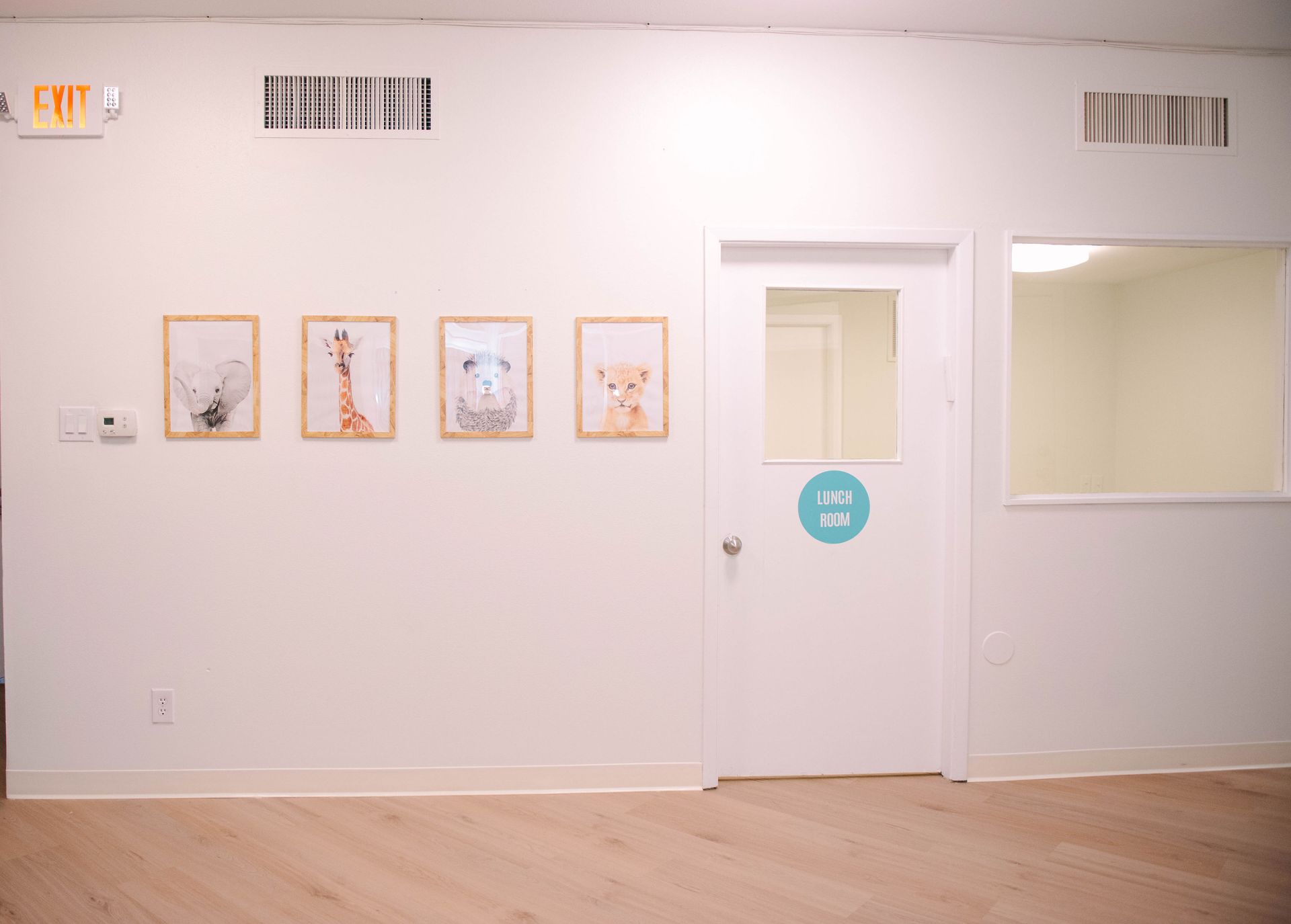 A room with a door and a few pictures on the wall.