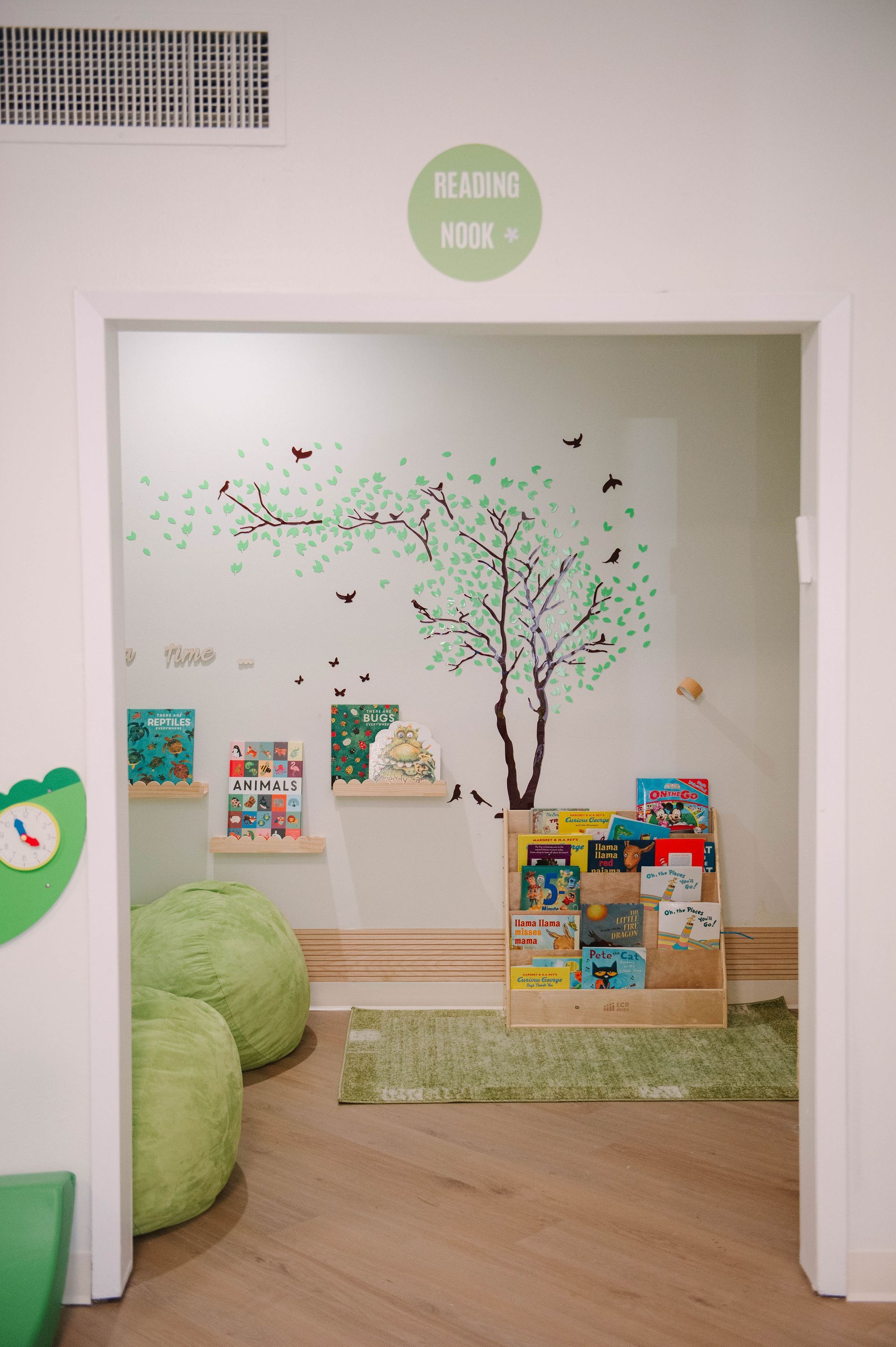 A room with a bookshelf and bean bag chairs in it.