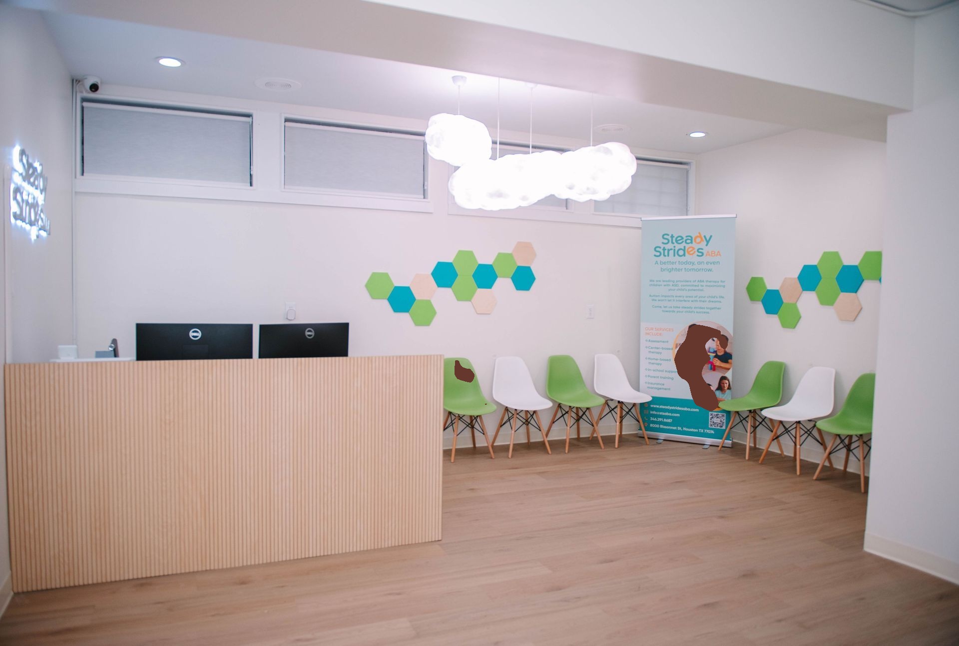 A waiting room with a desk and chairs in a hospital.