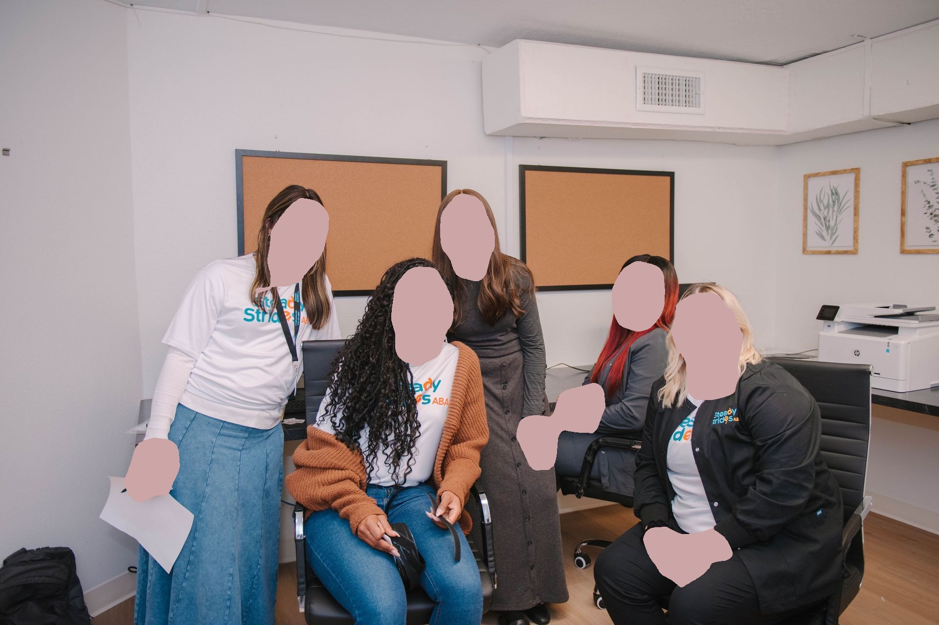 A group of women are posing for a picture in an office.