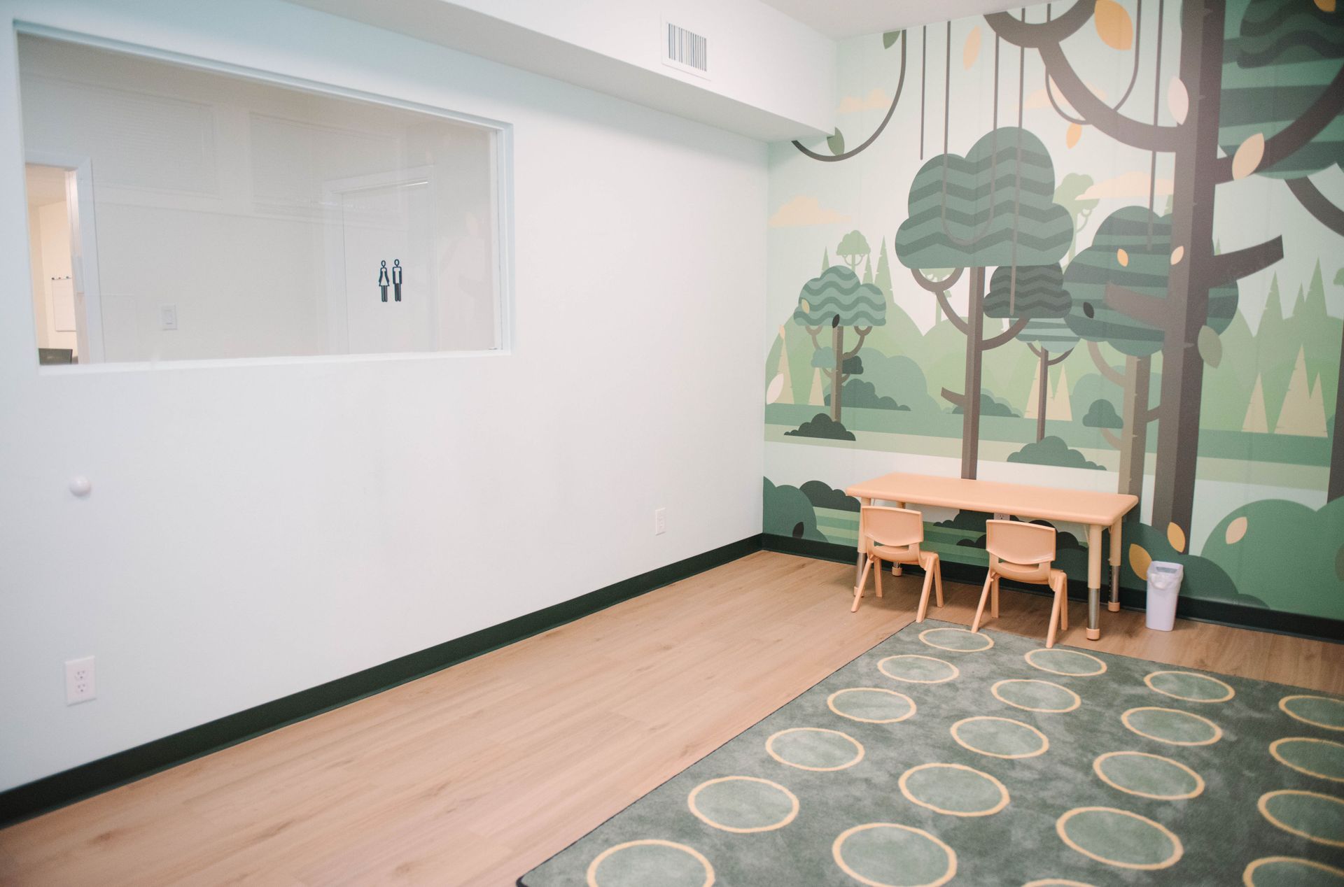 A room with a table and chairs and a mural on the wall.