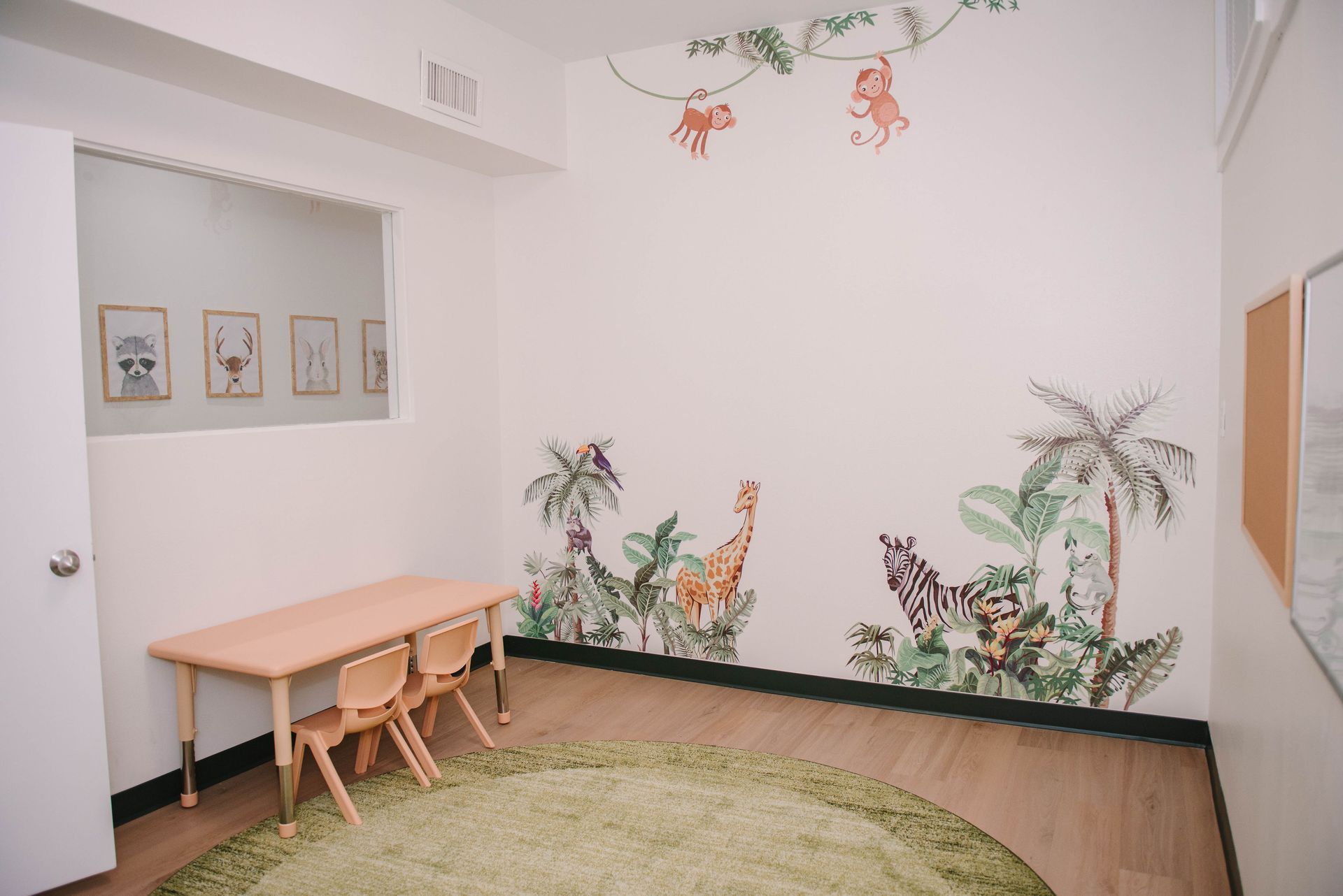 A room with a table and chairs and a mural on the wall.